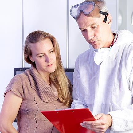 Worker and woman looking at paperwork